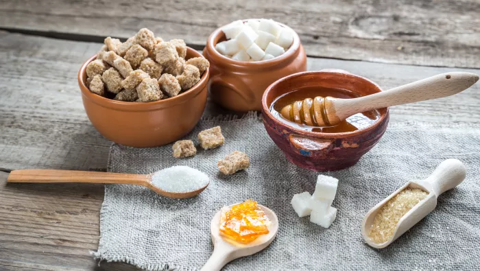 Different types of sugar (white & brown sugar cubes, syrup and granulated sugar) 