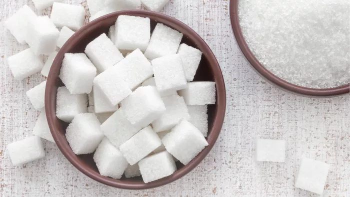 Different types of white sugar (sugar cubes and granulated sugar) 