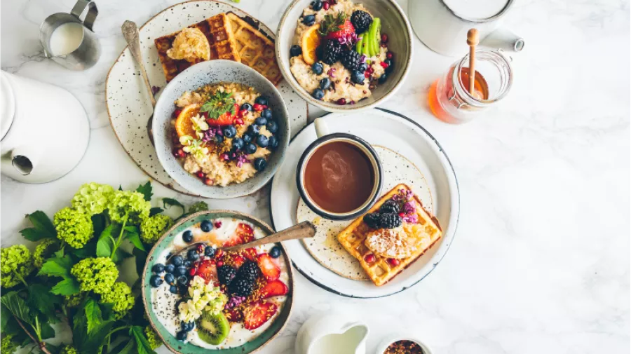 Bowls of cereals and sweet waffles with fruit 