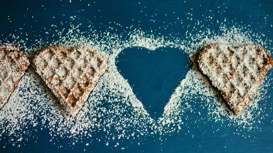 Heart shaped sweet waffles sprinkled with icing sugar 