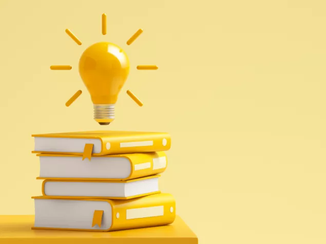 Lightbulb above pile of books