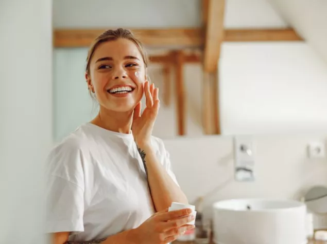 girl applying cream to skin