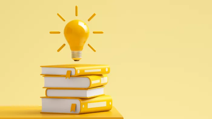 Lightbulb above pile of books